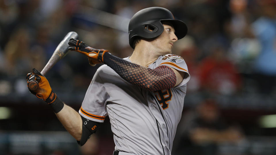 San Francisco Giants second baseman Scooter Gennett (14) hits in the first inning during a baseball game against the Arizona Diamondbacks, Sunday, Aug. 18, 2019, in Phoenix. (AP Photo/Rick Scuteri)