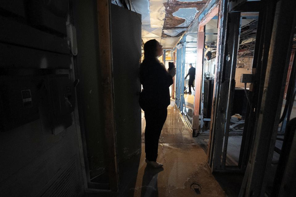 Tora Bonnier uses her cellphone flashlight to illuminate the eroded ceiling in the basement of the former Ho Toy Restaurant in Downtown Columbus. Bonnier purchased the building with plans to redevelop it into a multi-use venue.