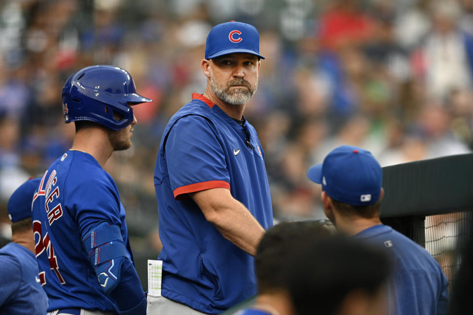 Chicago Cubs manager David Ross, center, looks into the dugout in the third inning of a baseball game against the Detroit Tigers, Monday, Aug. 21, 2023, in Detroit. (AP Photo/Jose Juarez)