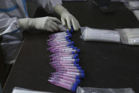 A health worker arranges swab samples of people to test for COVID-19 at a government hospital in Jammu, India, Thursday, Oct.29, 2020. India's confirmed coronavirus caseload surpassed 8 million on Thursday with daily infections dipping to the lowest level this week, as concerns grew over a major Hindu festival season and winter setting in. (AP Photo/Channi Anand)