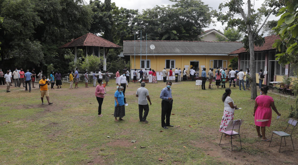 Sri Lankans stand in a queue to cast their votes outside a polling station in Colombo, Sri Lanka, Wednesday, Aug. 5, 2020. Sri Lankans started voting Wednesday to elect a new Parliament that is expected to give strong support to the powerful and popular Rajapaksa brothers. (AP Photo/Eranga Jayawardena)