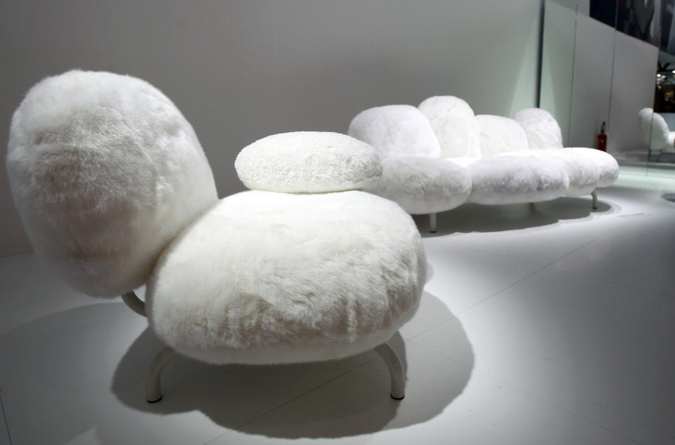 In this Tuesday, April 17, 2012 photo people look a sofa at the Edra Home company space during Milan's Furnishing Accessories Exhibition, in Milan, Italy. The Milan Furniture Fair, a six-day event which ended Sunday, was full of experiment and whimsy. (AP Photo/Antonio Calanni)