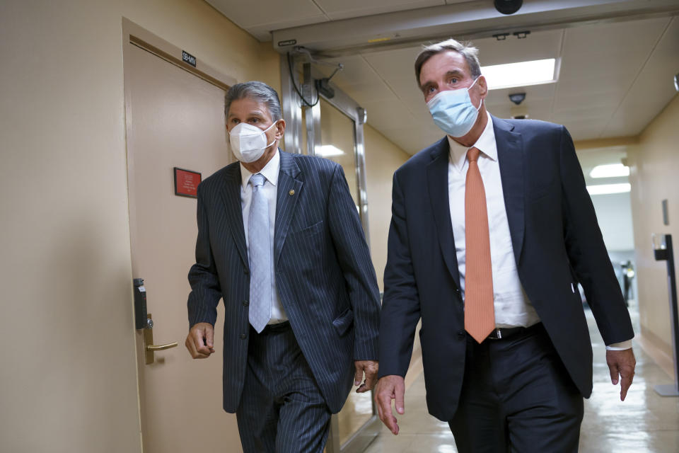 Sen. Joe Manchin, D-W.Va., left, and Sen. Mark Warner, D-Va., key moderates, return to the Senate chamber for a vote at the Capitol in Washington, Thursday, Sept. 23, 2021. Senate Majority Leader Chuck Schumer and House Speaker Nancy Pelosi say they and the White House have agreed to a "framework" to pay for their emerging $3.5 trillion social and environment bill. (AP Photo/J. Scott Applewhite)