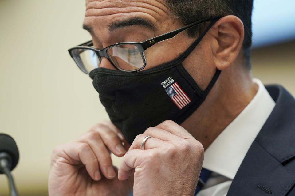 Treasury Secretary Steven Mnuchin adjusts his face mask during a House Financial Services Committee hearing on Capitol Hill in Washington, Wednesday, Dec. 2, 2020. (Greg Nash/Pool via AP)