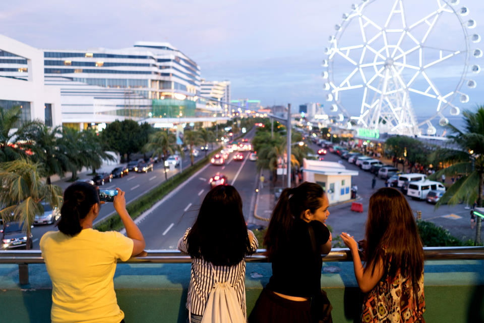 People stand on a bridge near the SM Mall of Asia complex in Pasay City, Metro Manila, the Philippines. (Photo: Getty Images)
