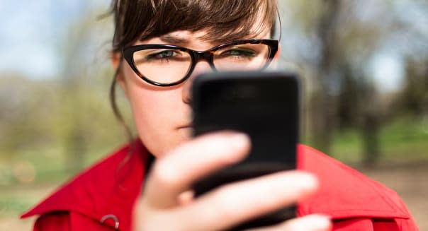 Woman in city park looking at smartphone