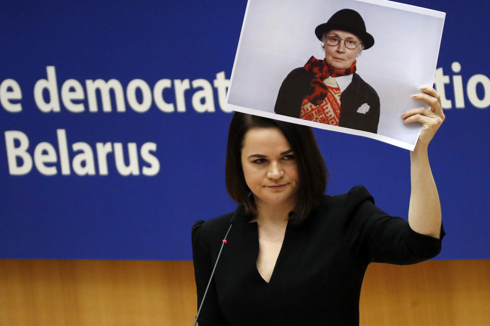 FILE In this file photo taken on Wednesday, Dec. 16, 2020, Belarusian opposition politician Sviatlana Tsikhanouskaya holds a picture of Belarusian opposition activist Nina Baginskaya as she gives a speech during the Sakharov Prize ceremony at the European Parliament in Brussels. A wave of COVID-19 has spread through Belarusian jails packed with people imprisoned for taking part in four months of protests against the nation’s authoritarian president. Activists, who tested positive after being released, describe massively overcrowded cells and the lack of basic amenities, and some even allege that the authorities have deliberately spread contagion among political prisoners. (AP Photo/Francisco Seco, File)