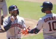 Houston Astros' Jose Altuve (27) is congratulated by teammate Yuli Gurriel (10) after scoring on a sacrifice fly against the Minnesota Twins in the first inning of a baseball game, Sunday, June 13, 2021, in Minneapolis. (AP Photo/Andy Clayton-King)