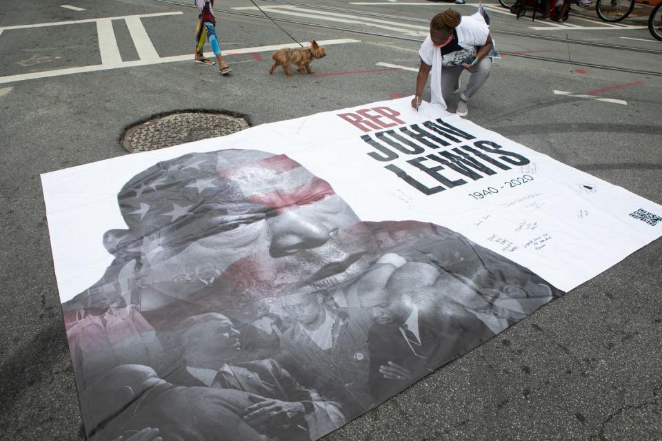 <p>A poster depicting Lewis sits outside Ebenezer Baptist Church in Atlanta. Mourners approach the poster to sign it and write notes. </p>