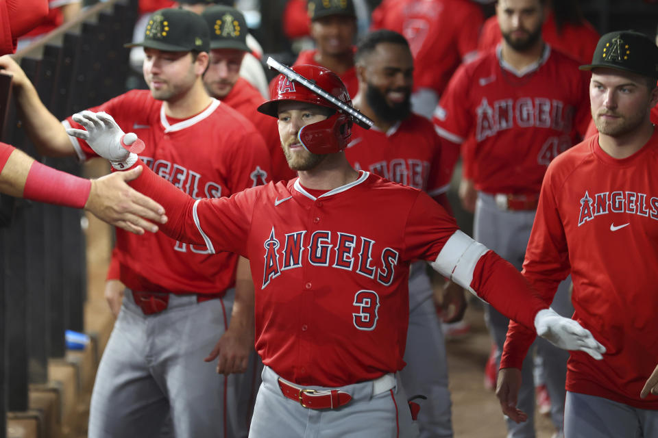 Los Angeles Angels Taylor Ward (3) celebrates in the dugout after a solo home run against the Texas Rangers in the fourth inning of a baseball game Saturday, May 18, 2024, in Arlington, Texas. (AP Photo/Richard W. Rodriguez)