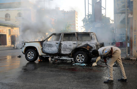 A policeman looks at the wreckage of a car burnt after an explosion in Mogadishu, Somalia September 22, 2018. REUTERS/Feisal Omar