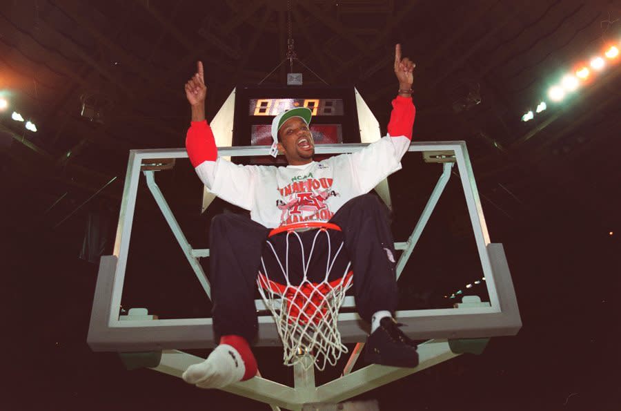 8 Apr 1994: INJURED ARKANSAS GUARD ROGER CRAWFORD CELEBRATES ATOP THE RIM AFTER THE RAZORBACKS DEFEATED DUKE, 76-72, IN CHARLOTTE, NORTH CAROLINA. THE TEAM HAD DEDICATED THEIR TOURNAMENT PLAY TO CRAWFORD, WHO WAS INJURED EARLIER IN THE SEASON.