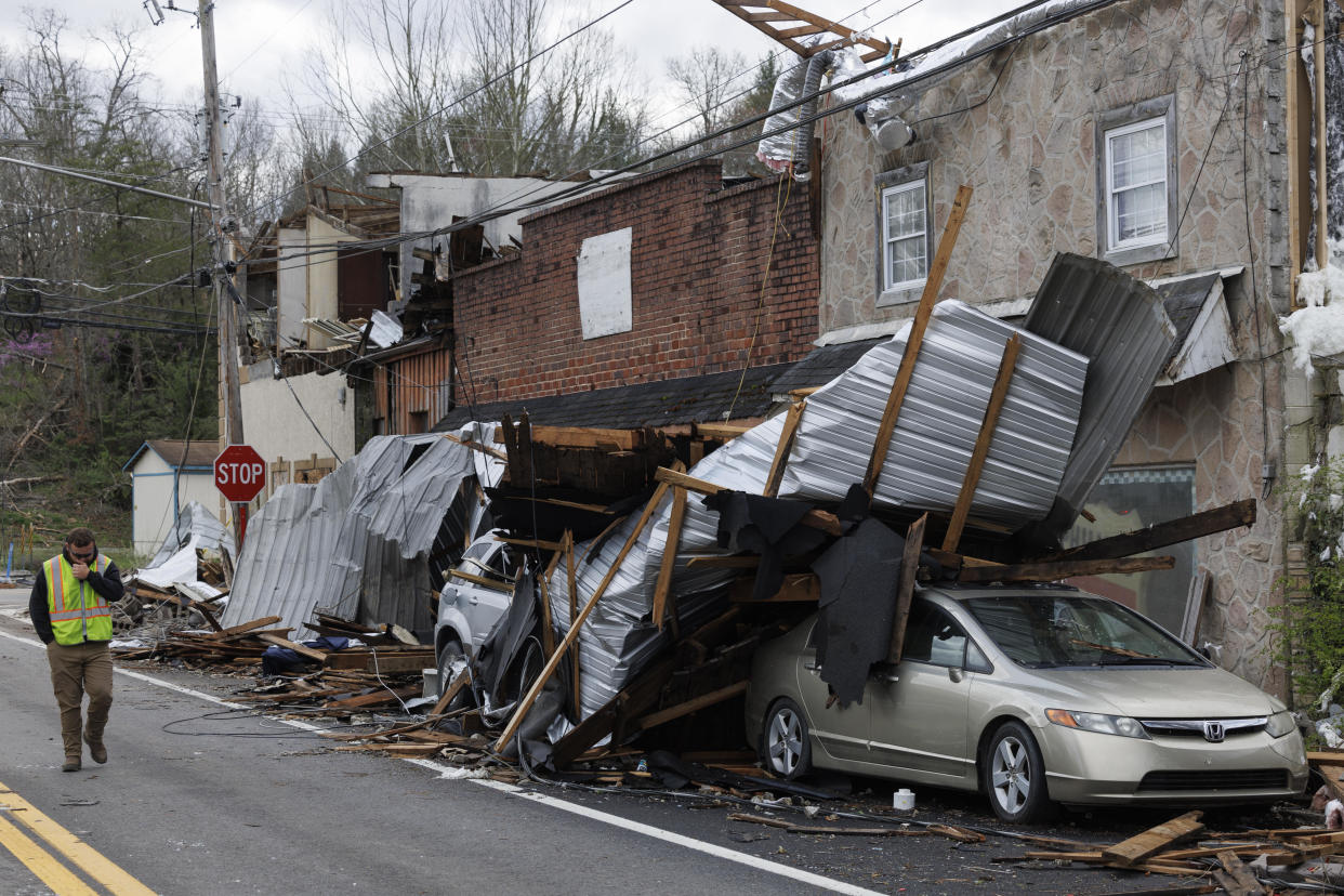 A utility worker walks past buildings damaged by a tornado on April 3, 2024, in Sunbright, Tennessee. / Credit: Brett Carlsen / Getty Images