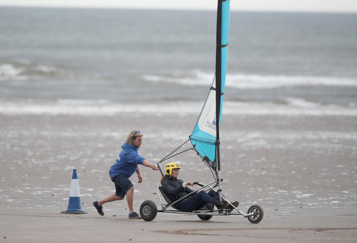 EMBARGOED UNTIL 1050 WEDNESDAY MAY 26 The Duchess of Cambridge with a group of young carers land yachting on the beach at St Andrews. Picture date: Wednesday May 26, 2021.