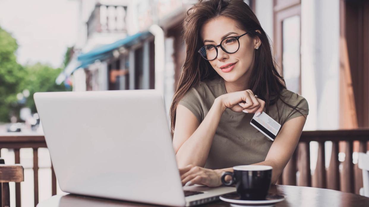 Businesswoman using laptop and credit card.