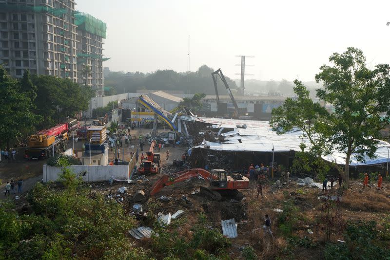 Members of rescue teams search for survivors amidst the debris after a massive billboard fell during a rainstorm in Mumbai