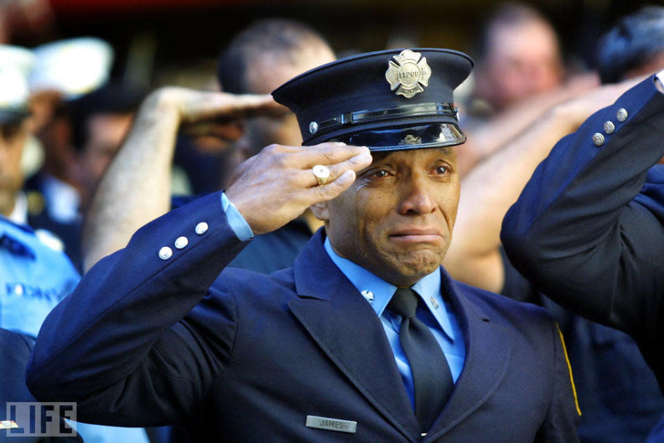 On 9/11, the New York City Police Department lost 23 officers. The Port Authority police lost 37. The FDNY's dead numbered 343. Here, firefighter Tony James cries while attending the funeral service for New York Fire Department chaplain Mychal Judge at New York's St. Francis of Assisi Church, September 15, 2001. Photographer Joe Raedle, who attended and photographed funerals for weeks after September 11, told LIFE.com of this shot: "Anytime you see a fireman or a symbol of strength breaking down like that, it resonates." In fact, Raedle's photograph, with its ghostly echoes of James' salute surrounding his tear-streaked face, speaks to how millions of people around the world felt in the days and weeks after the attacks: namely, that strength was what we all needed most, and that it was the one thing that was hardest to find. <br><br>(Photo: Joe Raedle/Getty Images )<br><br>For the full photo collection, go to <a href="http://www.life.com/gallery/59971/911-the-25-most-powerful-photos#index/0" rel="nofollow noopener" target="_blank" data-ylk="slk:LIFE.com;elm:context_link;itc:0;sec:content-canvas" class="link ">LIFE.com</a>