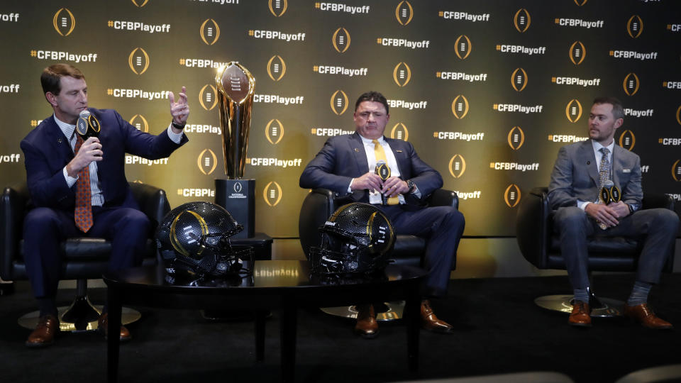 Clemson head coach Dabo Swinney, left, speaks as LSU head coach Ed Orgeron and Oklahoma head coach Lincoln Riley, right, look on during a news conference ahead for the College Football playoffs Thursday, Dec. 12, 2019, in Atlanta. Ryan Day of Ohio State was unable to attend. (AP Photo/John Bazemore)