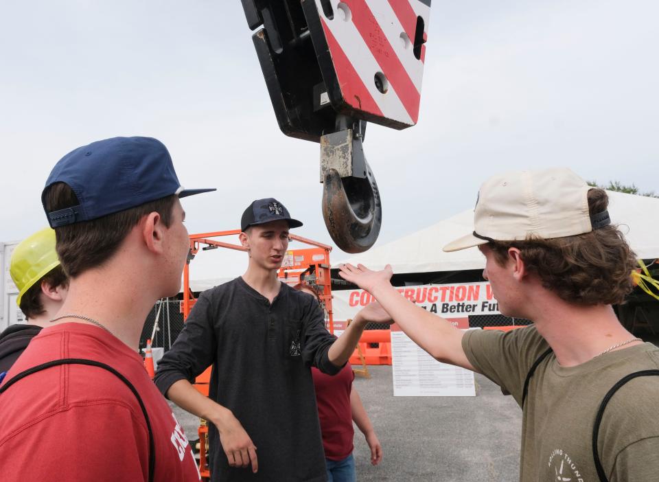 Ninth grade students tour the displays at the Worlds of Work Thursday, Oct. 5, 2023, at Shelton State Community College. At the McAbee Construction display students JB Bishop, right, and Mason Redding, left, get a demonstration of a large crane from Cole Glasgow. The students are from Sipsey Valley High.