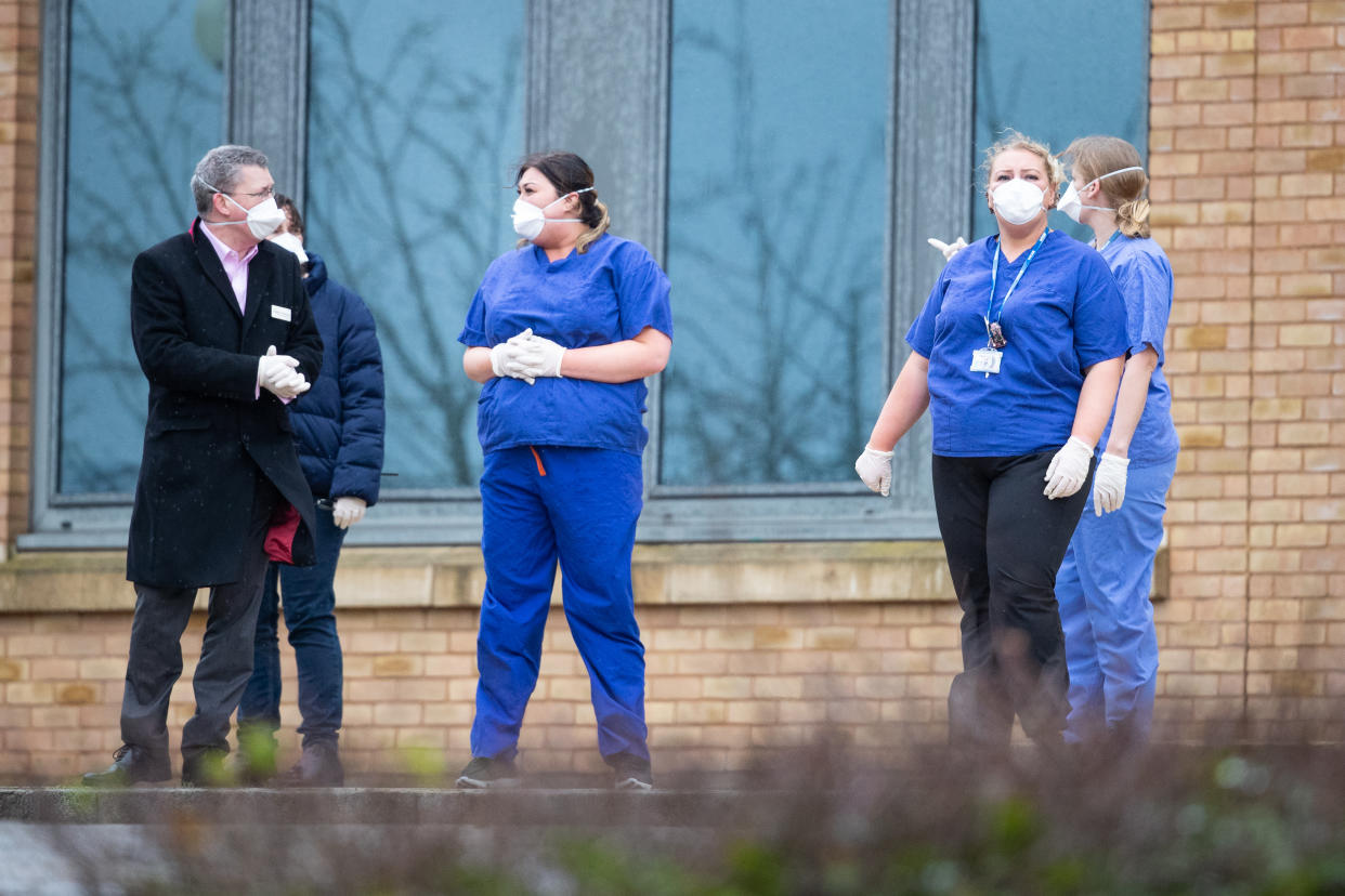 Members of staff wait as coaches carrying Coronavirus evacuees arrive at Kents Hill Park Training and Conference Centre, in Milton Keynes, after being repatriated to the UK from the coronavirus-hit city of Wuhan in China.