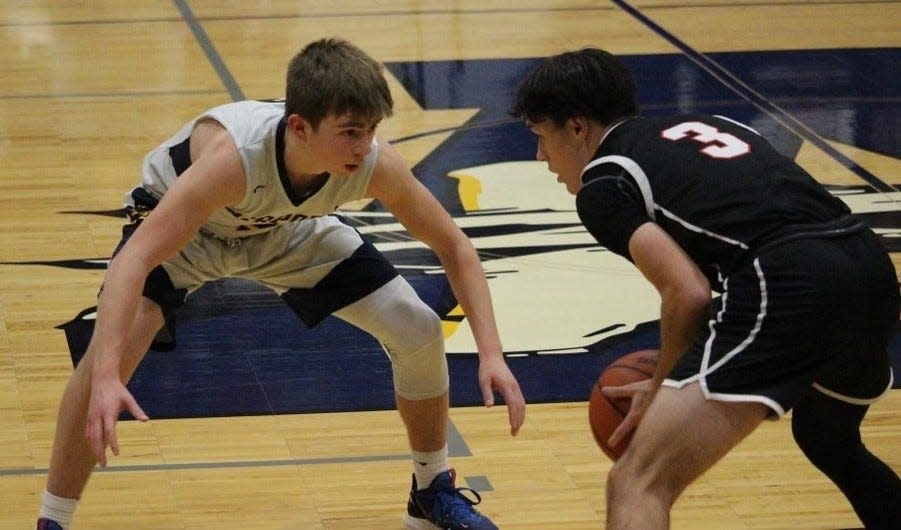 Airport's Brett Moore locks down on defense against Tyler Denham of Milan Friday night.