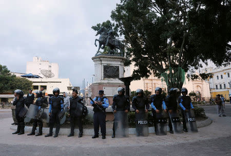 Riot police officers stand guard at the main square in downtown Tegucigalpa minutes before the start time of a curfew enforced by Honduras government while the country is still mired in chaos over a contested presidential election, Honduras December 2, 2017. REUTERS/Henry Romero