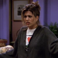 rachel in a white t-shirt with a heart flower and a big gray cardigan on friends