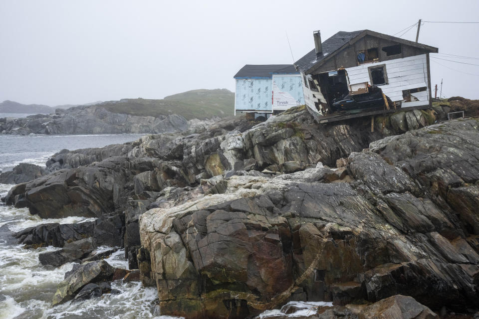 Destroyed houses perch on the edge of the rocks following Fiona in Burnt Island, Newfoundland and Labrador, on Tuesday, Sept. 27, 2022. After surging north from the Caribbean as a major hurricane, Fiona came ashore before dawn Saturday as a post-tropical cyclone, battering Nova Scotia, Prince Edward Island, Newfoundland and Quebec with hurricane-strength winds, rains and waves. (Frank Gunn/The Canadian Press via AP)