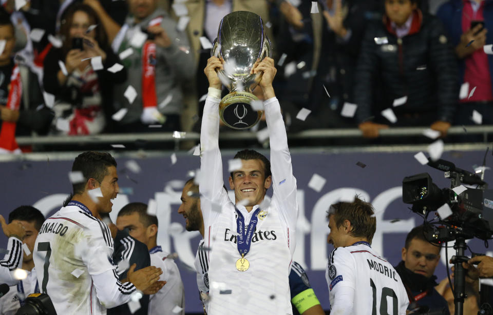 FILE - Real Madrid's Gareth Bale, centre, lifts the trophy after beating Sevilla 2-0 during the UEFA Super Cup soccer match between Read Madrid and Sevilla at Cardiff City Stadium in Wales Tuesday, Aug. 12, 2014. AP Photo/Kirsty Wigglesworth, File)