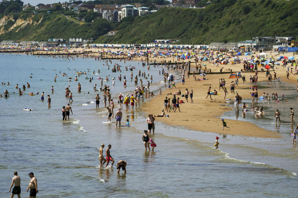 People enjoy the weather on Bournemouth beach in Dorset, England, Monday July 19, 2021. (Steve Parsons/PA via AP)