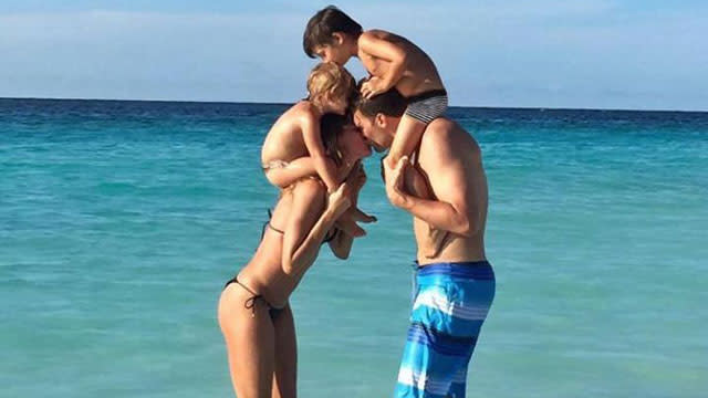 Tom Brady seems to be doing just fine despite his four-game NFL suspension. The Super Bowl winner's wife, supermodel Gisele Bundchen, wished him a happy birthday by sharing a photo of herself in a bikini, kissing her husband in the ocean while they each have one of their children on their shoulders. Daughter Vivian, 2, sat on top of Gisele, while 5-year-old son Benjamin climbed on top of Tom. <strong>PICS: Gisele Celebrates Tom Brady's Super Bowl Win with an Adorable Kiss </strong> "Happy birthday my love!" Gisele, 35, wrote. "We're so blessed to have you in our lives. Thank you for always giving us so much love. We love you!" Happy birthday my love! We're so blessed to have you in our lives. Thank you for always giving us so much love. We love...Posted by Gisele Bündchen on Monday, August 3, 2015 Tom turned 38 on Monday. The family also celebrated Tom's fourth Super Bowl win with kisses earlier this year when the New England Patriots prevailed over the Seattle Seahawks. Getty Images No doubt the couple is genetically perfect, but where do they fall on ET's list of the top five power couples? Watch the video below!