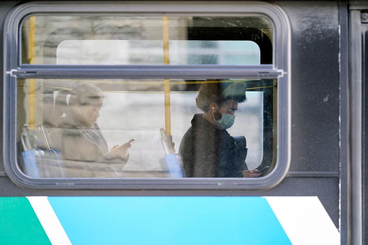 A man in a mask sits on a bus on campus at Western University in London, Ontario on March 13, 2020 where in person classes have been suspended for the rest of the school year in favour of online instruction due to concerns over the novel coronavirus, COVID-19. (Photo by Geoff Robins / AFP) (Photo by GEOFF ROBINS/AFP via Getty Images)