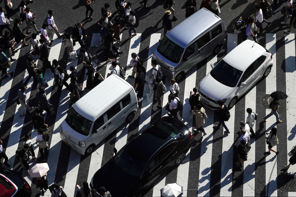 Pedestrians walk across the famous Shibuya crossing as vehicles are stuck in traffic Thursday, June 13, 2019, in Tokyo. It's not just a crossing. Located just outside Shibuya Station, the scramble crossing is one of the top tourist attractions in Japan. It's so famous that there's an observation deck on the rooftop of a building built to watch the crossing. During rush hour, an estimated 1000 to 2500 people cross the intersection during each traffic light change. (AP Photo/Jae C. Hong)