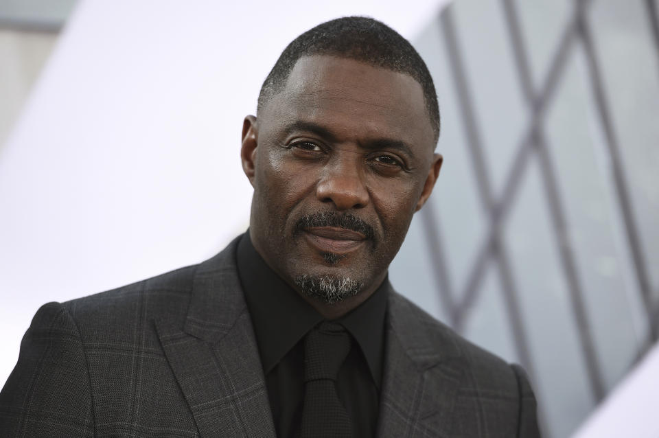 FILE - In this July 13, 2019, file photo, Idris Elba arrives at the Los Angeles premiere of "Fast & Furious Presents: Hobbs & Shaw." Elba said in an Instagram post on Monday, March 16, 2020 that he has tested positive for the coronavirus and is isolating himself, but has shown no symptoms yet. (Photo by Jordan Strauss/Invision/AP, File)