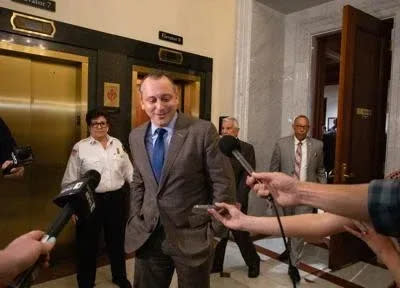 State Rep. Aaron Michlewitz, D-Boston, walks toward a group of reporters after exiting a House Democratic Caucus meeting on March 6.  Michlewitz, who is the House Committee on Ways and Means chair, said inaction at the federal level has forced state legislators to "make difficult decisions" in regards to housing the homeless.