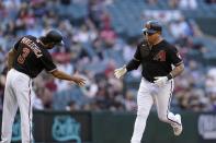 Arizona Diamondbacks' Asdrubal Cabrera, right, celebrates his home run against the Cincinnati Reds with third base coach Tony Perezchica (3) during the fourth inning of a baseball game Saturday, April 10, 2021, in Phoenix. (AP Photo/Ross D. Franklin)