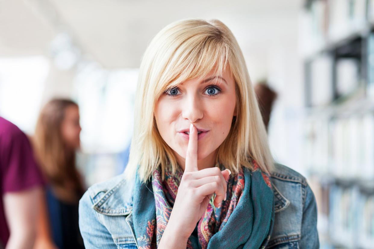 Woman putting finger to her mouth and signify shh