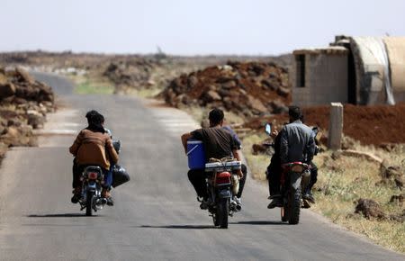 People ride their motorbikes with belongings in Deraa countryside, Syria June 22, 2018. REUTERS/Alaa al-Faqir