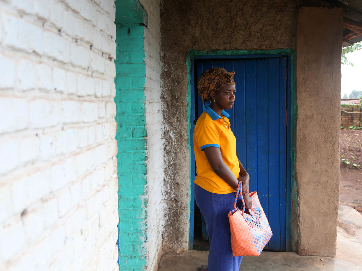 Outside the house she shares with her mother, Angel walks down the street to buy sugar in Ngoma Sector, Rwanda, in the southern part of the country near Huye (formerly known as Butare): Photography by Whitney Shefte