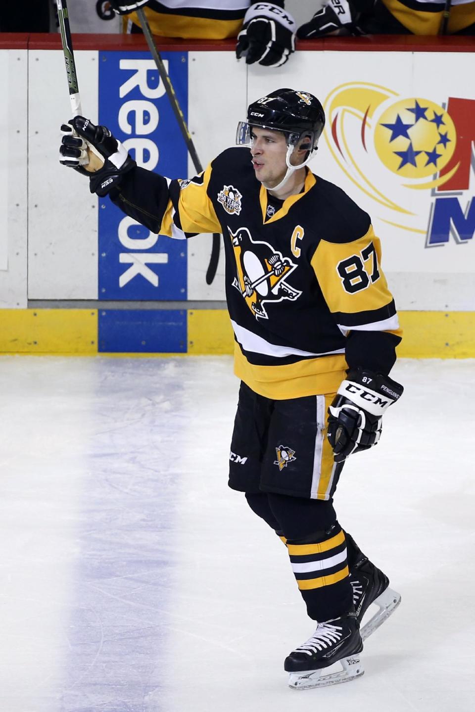 Pittsburgh Penguins' Sidney Crosby acknowledges fans as he skates back to the bench after assisting on a goal by Chris Kunitz, for the 1,000th point of his NHL career, during the first period of the team's hockey game against the Winnipeg Jets in Pittsburgh, Thursday, Feb. 16, 2017. (AP Photo/Gene J. Puskar)