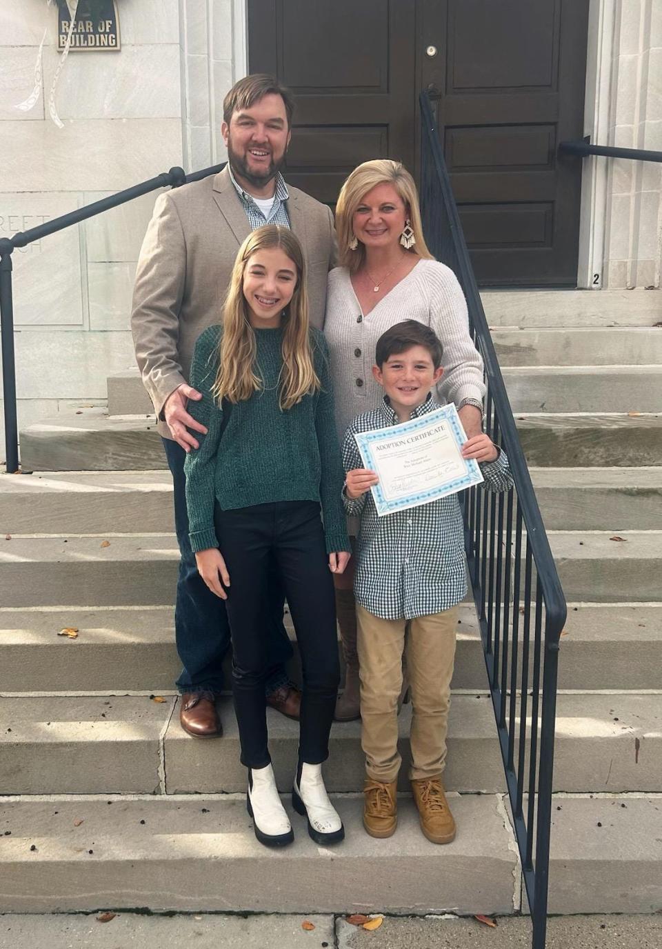 Evan and Julie Akins stand with daughter, Priscilla Akins, 13, and newly adopted son, Riley Akins, 10, on the Forrest County Courthouse steps after a mass adoption ceremony Monday in Hattiesburg.