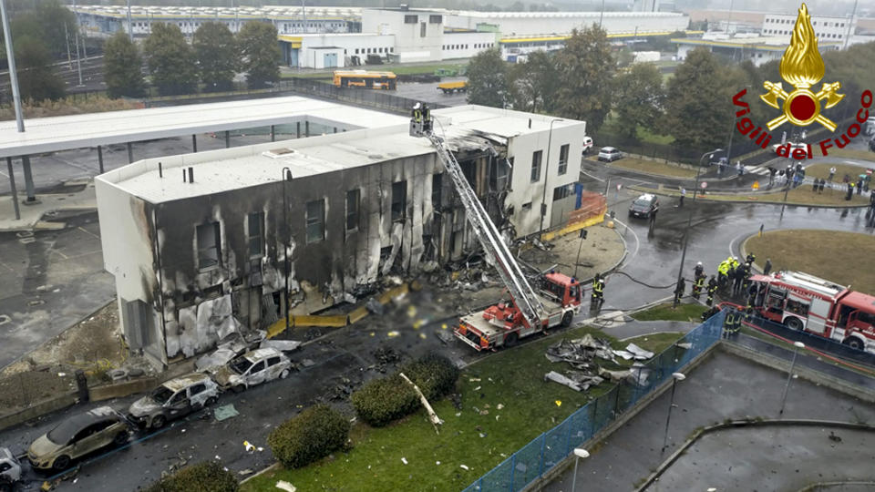 Firefighters work on the site of a plane crash, in San Donato Milanese suburb of Milan, Italy, Sunday, Oct. 3, 2021. A small private plane has crashed into a vacant office building in a Milan suburb. Italian news reports said all eight persons aboard were killed. Firefighters tweeted that no one other than those aboard were involved in the crash Sunday afternoon near a subway station in San Donato Milanese. (Vigili del Fuoco via AP)