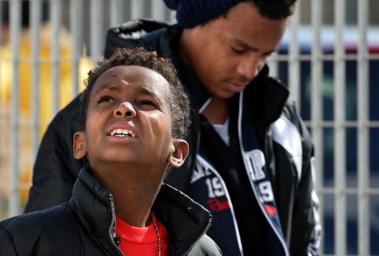 Tanjin, an 11-year-old Eritrean boy who arrived on a boat from Tripoli without his parents, waits at the port of Lampedusa, Italy, to board a ferry bound for Porto Empedocle in Sicily on February 20, 2015