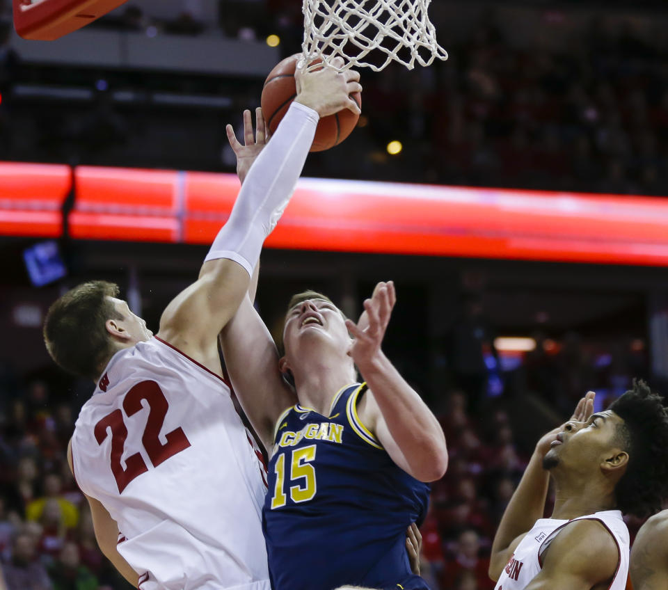 Wisconsin's Ethan Happ (22) and Michigan's Jon Teske (15) battle for a rebound during the first half of an NCAA college basketball game Saturday, Jan. 19, 2019, in Madison, Wis. (AP Photo/Andy Manis)