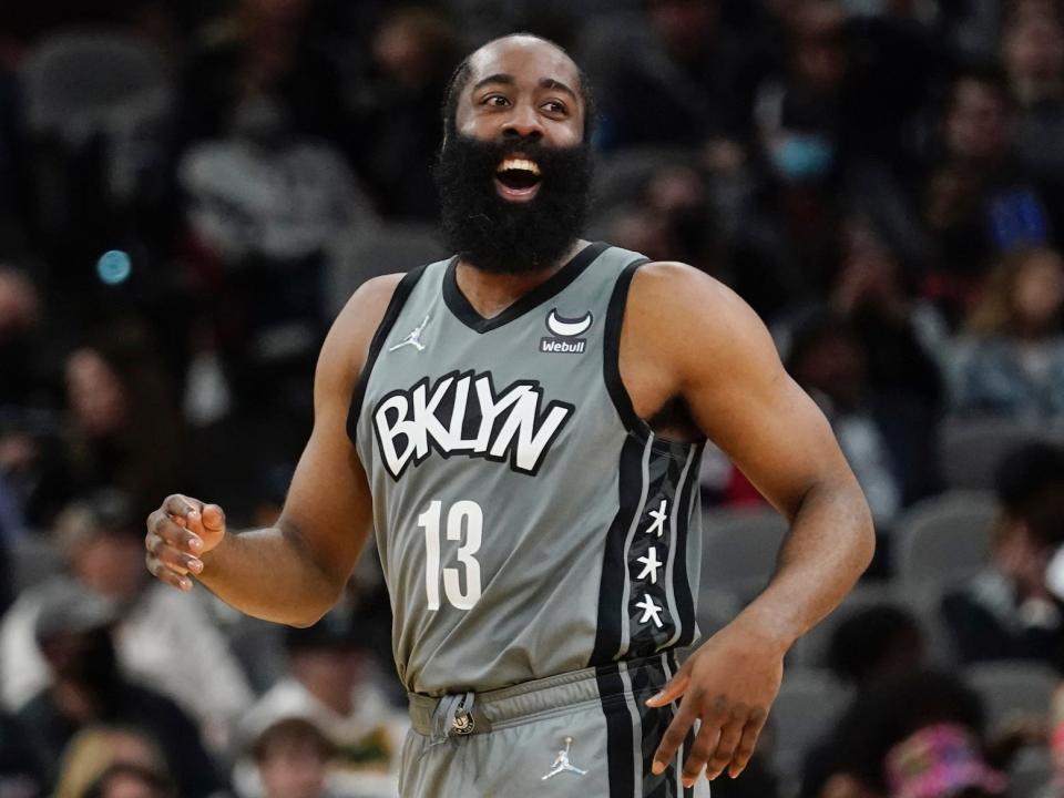 James Harden laughs while on the court in 2022.