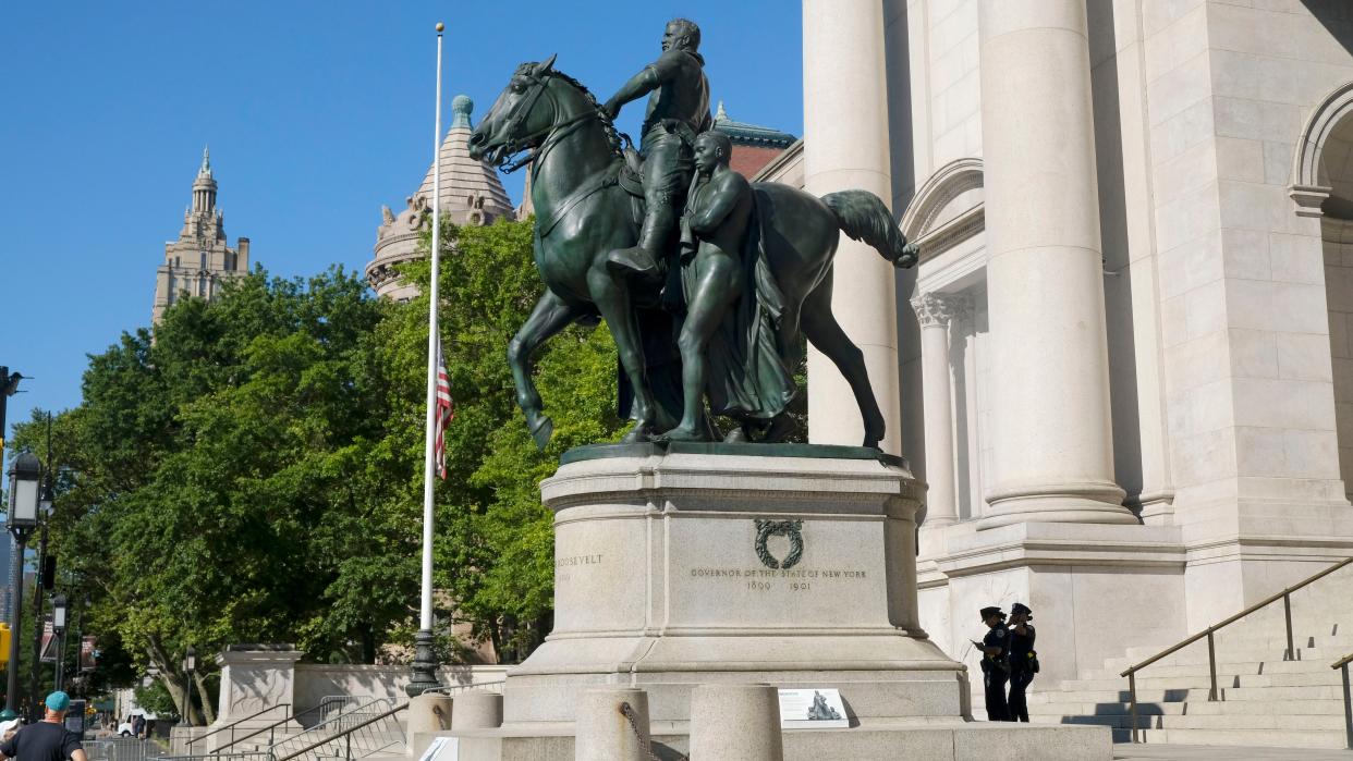 NYPD officers are seen guarding the equestrian statue of Theodore Roosevelt, a 1939 bronze sculpture by James Earle Fraser outside the American Museum of Natural History, on June 22, 2020. On Sunday, Mayor Bill de Blasio and the American Museum of Natural History announced that they will remove the prominent statue of Theodore Roosevelt from its entrance after years of objections that it symbolizes colonial expansion and racial discrimination. The bronze statue that has stood at the museum's Central Park West entrance since 1940 depicts Roosevelt on horseback with a Native American man and an African man standing next to the horse.