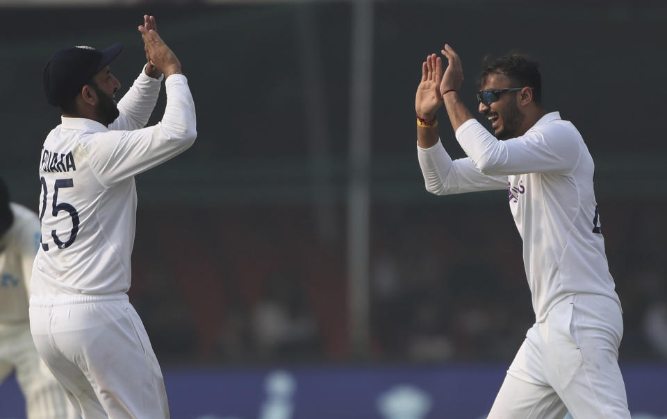India's bowler Axar Patel, right, celebrates the dismissal of New Zealand's Tom Blundell with his teammate Cheteshwar Pujara during the day three of their first test cricket match in Kanpur, India, Saturday, Nov. 27, 2021. (AP Photo/Altaf Qadri)