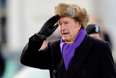 FILE PHOTO - ormer U.S. President George H.W. Bush salutes as he departs the East Front of the U.S. Capitol Building after Barack Obama was sworn in as the 44th president of the United States in Washington in this January 20, 2009 file photograph. REUTERS/Tannen Maury/Pool/File Photo