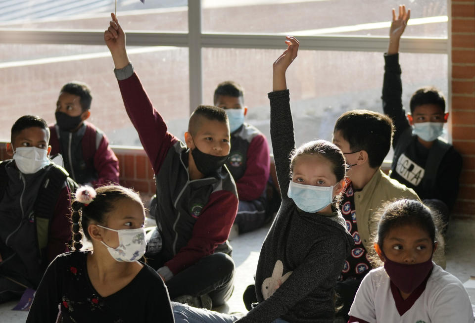Students attend their first day back to in-person learning amid the COVID-19 pandemic at the Emma Villegas public school in Bogota, Colombia, Monday, Jan. 24, 2022. Students across the capital returned to in-person learning at 100% capacity. (AP Photo/Fernando Vergara)
