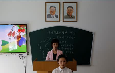 A teacher stands under the portraits of late North Korean leaders Kim Il-sung (L) and Kim Jong-il during a lecture at a teachers' training college during a government organised visit for foreign reporters ahead of the 70th anniversary of North Korea's foundation, in Pyongyang, September 7, 2018. REUTERS/Danish Siddiqui
